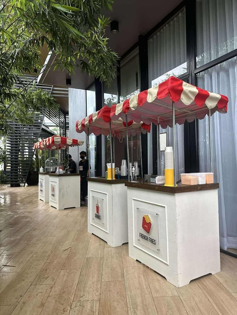 Drinks and French fries carts along a covered walkway